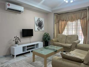 a living room with a couch and a tv at D’Lestari Homestay in Seri Kembangan