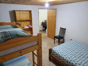 een slaapkamer met een bed, een bureau en een stoel bij Doña Isabel in Puerto Iguazú