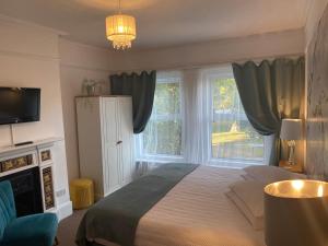 a bedroom with a bed and a large window at A & B Guest House Cambridge Ltd in Cambridge