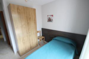 a bedroom with a bed and a wooden door at hostal trevol in Torelló