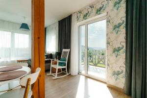 a living room with a table and a balcony at Jeleni Jar Apartamenty in Duszniki Zdrój