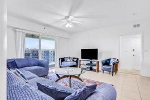 a living room with a couch and a tv at Oceanwalk Suite in New Smyrna Beach
