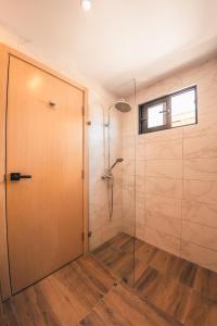 La salle de bains est pourvue d'une douche avec une porte en verre. dans l'établissement Fully Serviced Apartment at Regatta Living - 2G, à Saint-Domingue