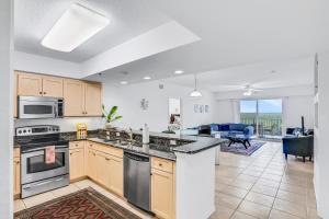 a kitchen with stainless steel appliances and a living room at Oceanwalk Suite in New Smyrna Beach