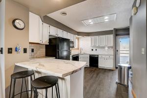 una cucina con bancone e 2 sgabelli da bar di Family Dreams Condo at Lighthouse Cove a Wisconsin Dells