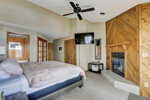 a bedroom with a bed with a fireplace and a ceiling fan at Family Dreams Condo at Lighthouse Cove in Wisconsin Dells