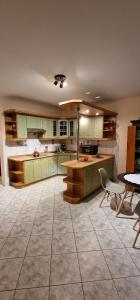a large kitchen with green cabinets and a table at Apartament Leśny in Nowy Targ