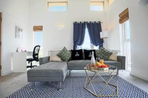 una sala de estar con un sofá y una mesa en Stylish 2 Bedroom Duplex Apartment - Close to City Centre - Balcony, Free Parking, Self-Check-In, Fast Wifi & Smart TVs by Yoko Property, en Milton Keynes