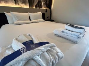 Una cama con toallas encima. en Novotel Santiago Vitacura, en Santiago