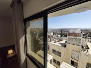 een raam met uitzicht op de stad bij (42)m luxury room in Ash Shumaysānī