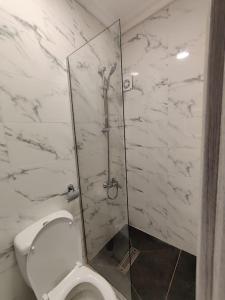 een badkamer met een toilet en een glazen douchecabine bij (42)m luxury room in Ash Shumaysānī