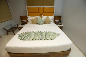 HOTEL THE GRANDLADHUKARA في دواركا: سرير عليه مبلغ من المال