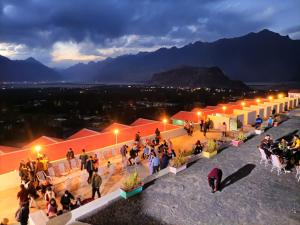 a crowd of people sitting on a rooftop at night at Hotel Mountain Lodge Skardu in Skardu