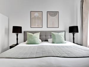 a bedroom with a large white bed with two lamps at Sanders Stage - Perfectly Planned Three-Bedroom Apartment Near Nyhavn in Copenhagen