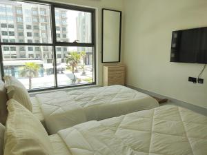 a bedroom with a large bed and a large window at 5*Amenities-2Br-15 min DxbApt,20min to Dubai Mall in Dubai