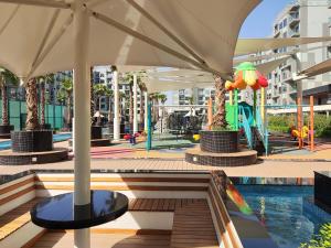 a playground with a slide and an umbrella at 5*Amenities-2Br-15 min DxbApt,20min to Dubai Mall in Dubai