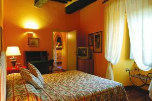 a bedroom with a bed and a television in it at La Locanda Del Castello in San Giovanni dʼAsso