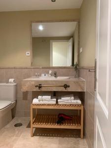 une salle de bain avec un lavabo et un miroir dans l'établissement Apartamento espacioso muy tranquilo con piscinas y jardines cercano a la playa, à Estepona