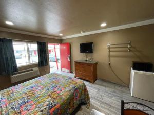 ein Hotelzimmer mit einem Bett und einem TV in der Unterkunft Hiland Motel in Long Beach