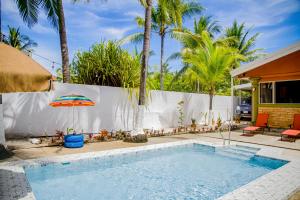 einen Pool mit Sonnenschirm und Palmen in der Unterkunft Sunset House in Tivives