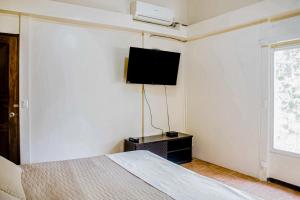ein Schlafzimmer mit einem Bett und einem TV an der Wand in der Unterkunft Sunset House in Tivives