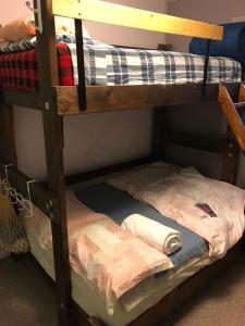 a wooden bunk bed with a mattress on the bottom bunk at Nice Bunk Bed in Whitehorse
