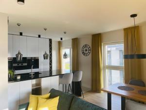 a kitchen and living room with a couch and a table at Tila II in Wałcz