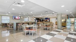 a restaurant with tables and chairs and a bar at Holiday Inn Express Williamsburg North, an IHG Hotel in Williamsburg