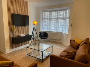 a living room with a couch and a glass table at Hill Garth Cottage - Luxury hotel style 2 bed with hot tub in Wooler