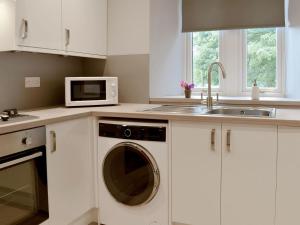 a kitchen with a washing machine and a sink at The Lodge in Linlithgow