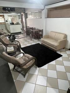 a living room with chairs and a couch and a table at Premium Center Hotel in Betim