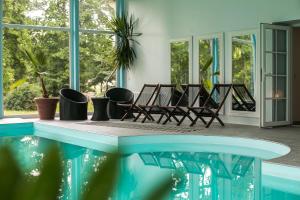 una habitación con sillas y una piscina en Ziemupes Muiža & SPA, en Ziemupe