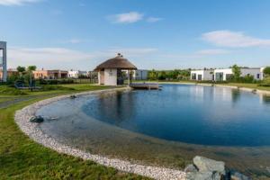 a swimming pool with a gazebo in a park at LUXUS Appartement am Golfplatz und Therme Lutzmannsburg in Zsira