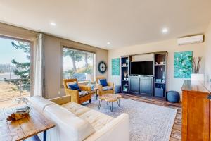 a living room with a white couch and a tv at Siuslaw Tides 2 in Florence