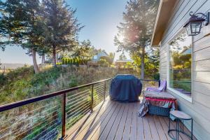 a deck with two chairs and a table on it at Siuslaw Tides 2 in Florence