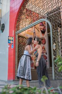 two women are standing in front of a mirror at Amazonia Siu Hostal in La Merced