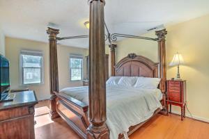 a bedroom with a four post bed with white sheets at Pet-Friendly Lawrenceville House with Deck! in Lawrenceville