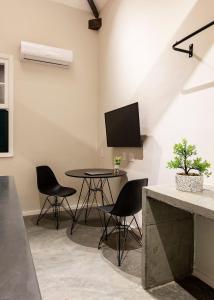 a dining room with a table and chairs and a tv at ZEST Pedroso in Sao Paulo