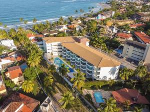 an aerial view of a resort with palm trees and the ocean at Aloha Residence in Porto De Galinhas