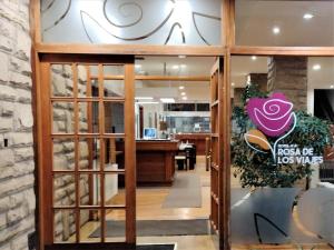 an entrance to a restaurant with a glass door at Rosa de los Viajes in San Martín de los Andes