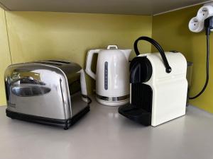 two toasters and a toaster and a coffee maker on a counter at Côté plage Nauzan Vue mer in Vaux-sur-Mer