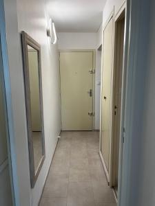 a hallway with two mirrors and a hallway with a door at Côté plage Nauzan Vue mer in Vaux-sur-Mer