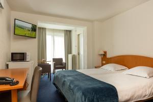 Cette chambre comprend un lit et un bureau. dans l'établissement Hotel Edenpark, à Brunssum