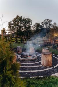 a fire pit with logs in a park at Jeleni Jar Apartamenty in Duszniki Zdrój
