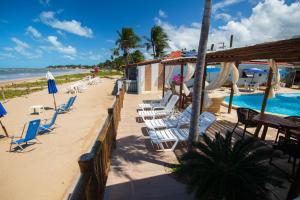 a beach with lounge chairs and a swimming pool at Pousada Shalom Beach in Maragogi