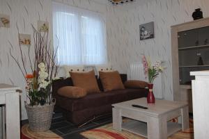 sala de estar con sofá marrón y mesa en Orchidee, en Comines