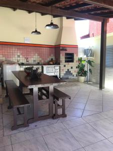 cocina con mesa y bancos en una habitación en J e E Apartamentos na Barra da Lagoa, en Florianópolis