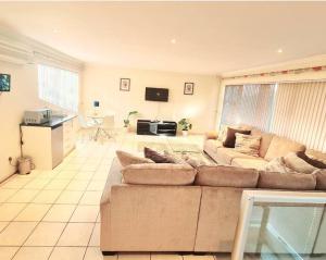 uma grande sala de estar com um sofá e uma televisão em Luxurious Pvt Apartment ,Power backup, Pool & Jaccuzi em Sandton