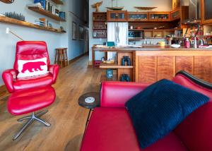 a living room with a red couch and a chair at Bjørn Holm in Port Renfrew