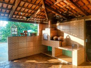 a room with a brick wall with vases on shelves at Chácara Recanto da Paz in Pirenópolis